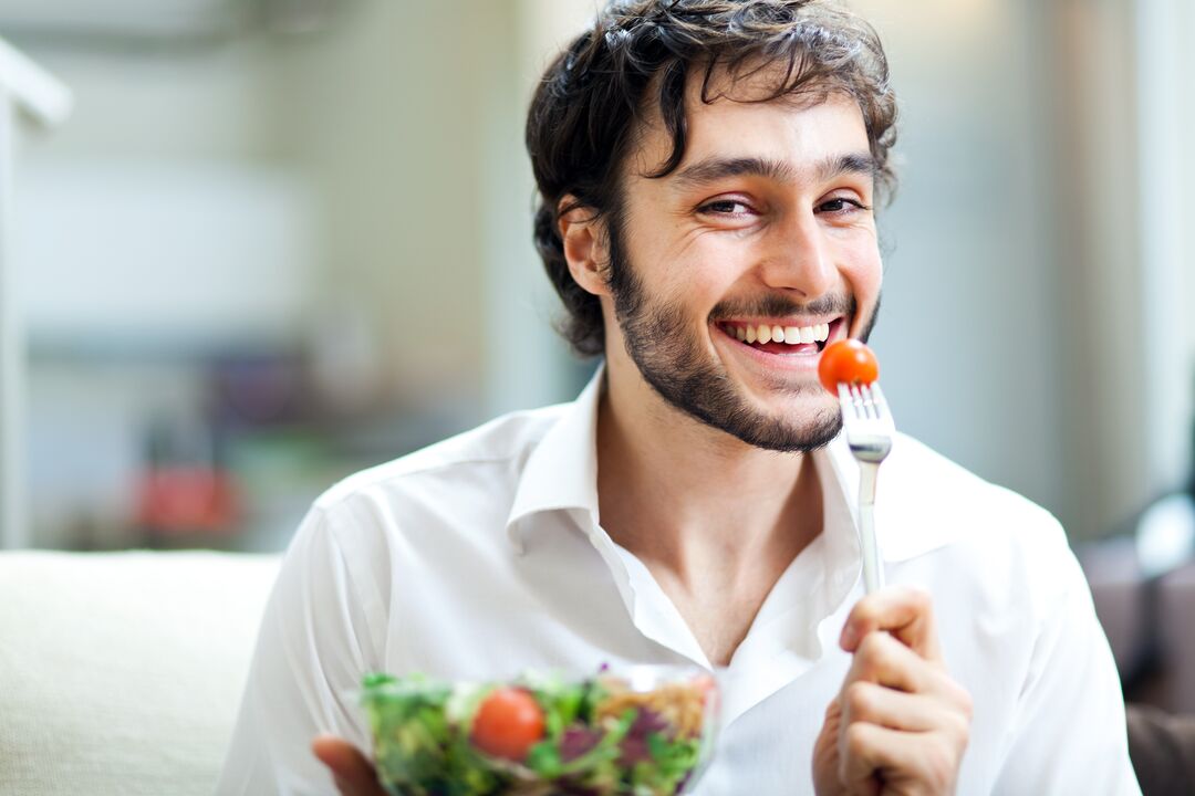 L'homme mange des légumes pour la puissance